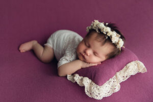 Baby auf lila Decke bei Neugeborenen-Shooting München