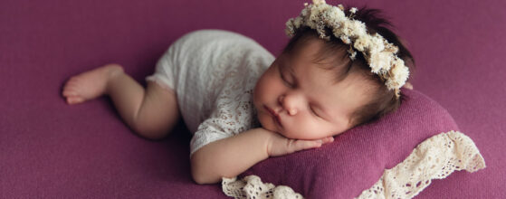 Baby auf lila Decke bei Neugeborenen-Shooting München